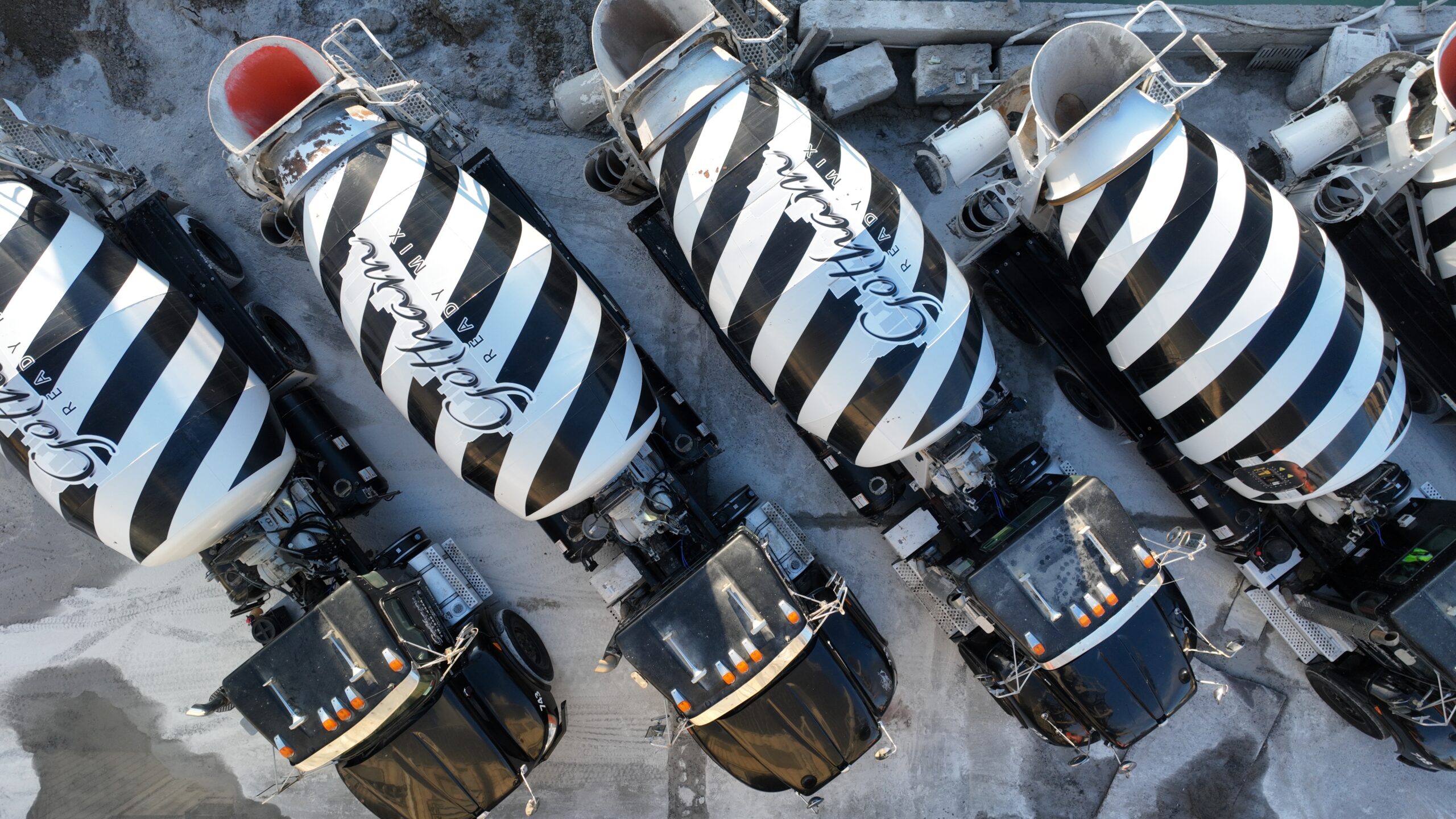 A group of Gotham Ready Mix trucks parked in a parking lot.